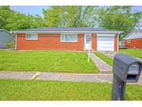 Charming red brick home featuring a well-maintained front yard and attached garage at 412 S Norfolk St, Indianapolis, IN 46241