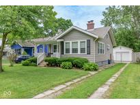 Charming home featuring a well-maintained lawn, manicured hedges, and a cozy front porch at 4922 Brookville Rd, Indianapolis, IN 46201