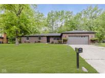 Brick home with a well-manicured lawn, mature trees, and an attached two-car garage at 5982 Melbourne Rd, Indianapolis, IN 46228