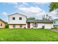 Two-story home with light siding, a green lawn, and a one-car garage at 6238 E 43Rd St, Indianapolis, IN 46226
