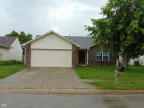 Charming single-Gathering home featuring brick and vinyl siding, a two-car garage, and mature landscaping at 8165 Amarillo Dr, Indianapolis, IN 46237