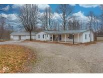 Charming single-story home with a covered porch, gravel driveway, and ample parking at 8230 W Pocket Hollow Rd, Gosport, IN 47433