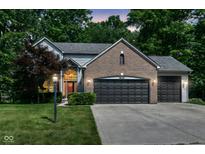 Charming two-story home showcasing a brick facade, two-car garage, and a well-manicured front lawn at 8530 Ardennes Dr, Fishers, IN 46038