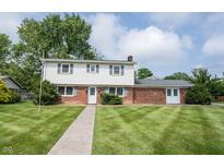 Charming two-story home boasts a brick and vinyl exterior with a well-manicured lawn at 10244 Washington Blvd, Carmel, IN 46280