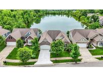 Aerial view of homes surrounding a serene lake, showcasing neighborhood layout and landscaping at 1071 Serenity Ct, Carmel, IN 46280