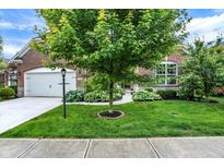 Charming brick home with a well-manicured front yard, mature trees, and a two-car garage at 1071 Serenity Ct, Carmel, IN 46280