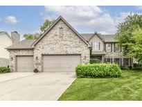 Traditional brick home with a well-maintained lawn and a three-car garage, offering curb appeal and ample parking at 10888 Weston Dr, Carmel, IN 46032