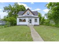 Charming two-story home with black roof, white siding and inviting landscaped front yard at 1150 W 30Th St, Indianapolis, IN 46208