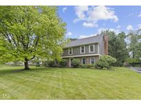 Charming two-story home with a large front yard and mature landscaping, creating a welcoming curb appeal at 11807 Rolling Springs Dr, Carmel, IN 46033