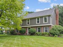 Charming two-story home featuring a manicured lawn and brick facade at 11807 Rolling Springs Dr, Carmel, IN 46033