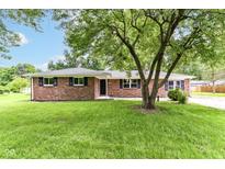 Charming single-story brick home with a well-manicured lawn and shade tree at 12029 Meadow Ln, Indianapolis, IN 46236