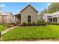 Charming home featuring a well-manicured lawn, complemented by neat shrubbery and a quaint, covered porch entry at 1211 W 10Th St, Muncie, IN 47302