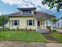 Charming home featuring a well-maintained lawn, inviting porch, and beautiful landscaping at 1336 Lafayette Ave, Columbus, IN 47201