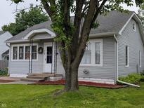 Charming home featuring gray siding, well-manicured lawn, and an inviting entrance with a decorative wreath at 1728 Newton St, Columbus, IN 47201