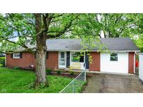 Charming one-story home featuring a brick facade, a well-manicured lawn, and mature trees providing ample shade at 1926 Fairmont Ct, Indianapolis, IN 46229