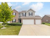 Charming two-story home with a two car garage, complemented by a beautiful green lawn and vibrant tree at 2260 Santa Fe Dr, Greenfield, IN 46140