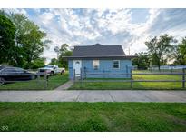 Charming exterior of a light blue home with well-maintained lawn and picket fence at 2358 Hovey St, Indianapolis, IN 46218