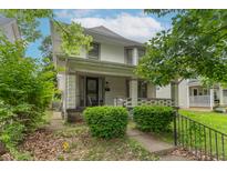 Charming two-story home featuring a cozy front porch and well-maintained landscaping in a residential neighborhood at 2823 Boulevard Pl, Indianapolis, IN 46208