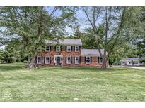 Charming two-story brick home featuring a well-maintained lawn and mature trees, offering classic curb appeal at 3030 E 236Th St, Cicero, IN 46034