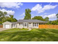 Charming single-story home with well-maintained lawn and landscaping on a sunny day with blue skies and fluffy clouds at 3113 Westenedge Dr, Columbus, IN 47203