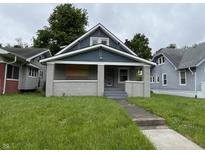 Charming two-story home featuring a covered front porch with brick supports and a well-sized front lawn at 3526 Evergreen Ave, Indianapolis, IN 46205
