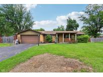 Charming single-story brick home with a well-maintained front lawn and covered porch at 410 E Southport Rd, Indianapolis, IN 46227