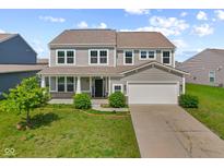 Two-story home with gray siding, inviting front porch, well-maintained lawn, and attached two-car garage at 4539 Maldenhair Dr, Indianapolis, IN 46239