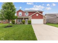 Charming two-story home with brick and red siding, attached garage, and well-manicured lawn at 4683 W Lawrence Way, New Palestine, IN 46163