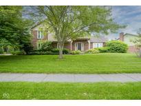 Charming brick home with a large front yard and mature tree providing shade at 4949 Jennings Dr, Carmel, IN 46033