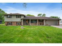 Charming two-story home features a welcoming front porch and an attached two car garage at 5631 N Olivia Dr, Alexandria, IN 46001
