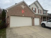 Two-car garage featuring brick facade and concrete driveway, providing ample parking and curb appeal at 5698 Yorktown Rd, Plainfield, IN 46168