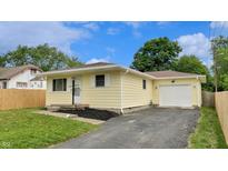 Charming yellow home with attached garage and inviting front yard, perfect for suburban living at 5806 E 19Th St, Indianapolis, IN 46218