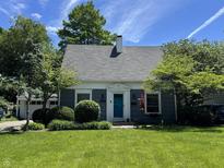Charming home featuring a manicured lawn and bright blue front door at 5889 Crestview Ave, Indianapolis, IN 46220