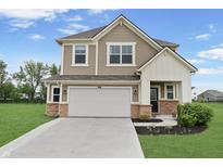 Charming two-story home boasts a manicured lawn, attached two-car garage, and a welcoming facade at 6917 Wolf Creek Ct, Whitestown, IN 46075