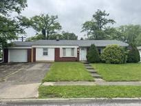 Charming single-story home featuring a well-maintained lawn and an attached one car garage with a concrete driveway at 7929 Roy Rd, Indianapolis, IN 46219