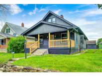 Charming home with a covered front porch and well-maintained lawn at 805 N Euclid Ave, Indianapolis, IN 46201