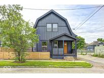 Charming house with a dark exterior, front porch, and a well-manicured lawn at 815 E 24Th E St, Indianapolis, IN 46205
