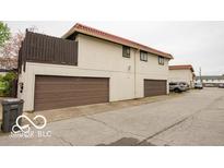 Two-story condo featuring a red tile roof and convenient garage parking at 8361 Paso Del Norte Ct, Indianapolis, IN 46227