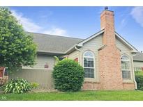 Charming home featuring a brick chimney, well-maintained lawn, and lush landscaping at 855 Gazebo Way # C, Greenwood, IN 46142