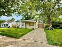 Charming single-story home featuring a well-manicured lawn and attached garage at 910 Lonsvale Dr, Anderson, IN 46013