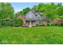 Charming two-story home featuring a well-manicured lawn, beautiful landscaping, and a welcoming front porch at 12961 Limberlost Dr, Carmel, IN 46033