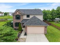 Two-story home with brick and vinyl siding, complemented by a well-manicured lawn and an attached two-car garage at 1408 Snead Cir, Avon, IN 46123