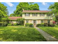 Charming two-story home featuring a stone facade and a well-manicured lawn at 1748 Sweet Gum Dr, Indianapolis, IN 46260