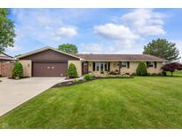 Charming ranch home with a well-manicured lawn and a two car garage at 1891 W 300 N, Anderson, IN 46011