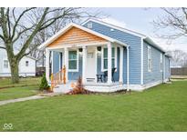 Charming bungalow with blue siding, wood accents, a cozy porch, and a well-manicured lawn at 2209 W 9Th St, Muncie, IN 47302