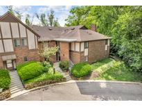 Brick townhouse with a well-kept lawn, lush landscaping, and a stone retaining wall, blending beauty and practicality at 2267 Rome Dr # A, Indianapolis, IN 46228