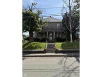 Traditional two-story home with a charming front porch and well-maintained lawn at 2310 Noble St, Anderson, IN 46016