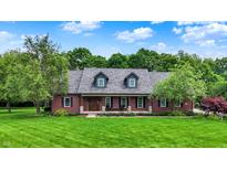 Charming brick home featuring a well-manicured lawn and inviting front porch at 4123 S Village Row, New Palestine, IN 46163