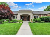 Inviting brick home with well-manicured landscaping, covered entrance, and charming curb appeal at 423 Bent Tree Ln, Indianapolis, IN 46260