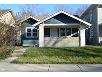 Charming blue house with a well-manicured lawn and inviting front porch in a residential neighborhood at 4231 Carrollton Ave, Indianapolis, IN 46205